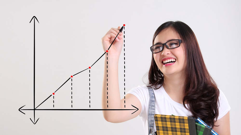 Fun cheerful school teenage girl drawing a chart with ascending line